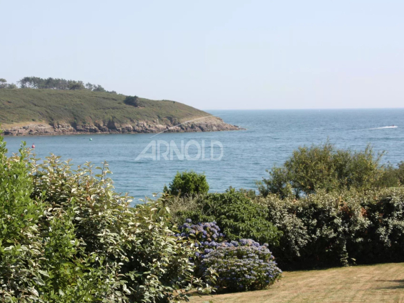 Vue panoramique sur l'océan et la plage depuis un jardin paysagé à Arzon.