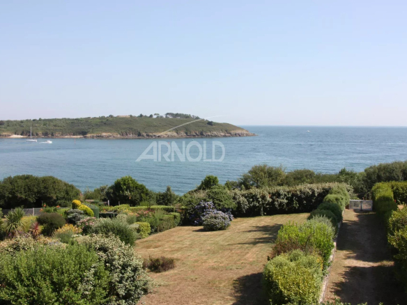 Vue panoramique sur l'océan et la plage depuis un terrain paysagé à Arzon.