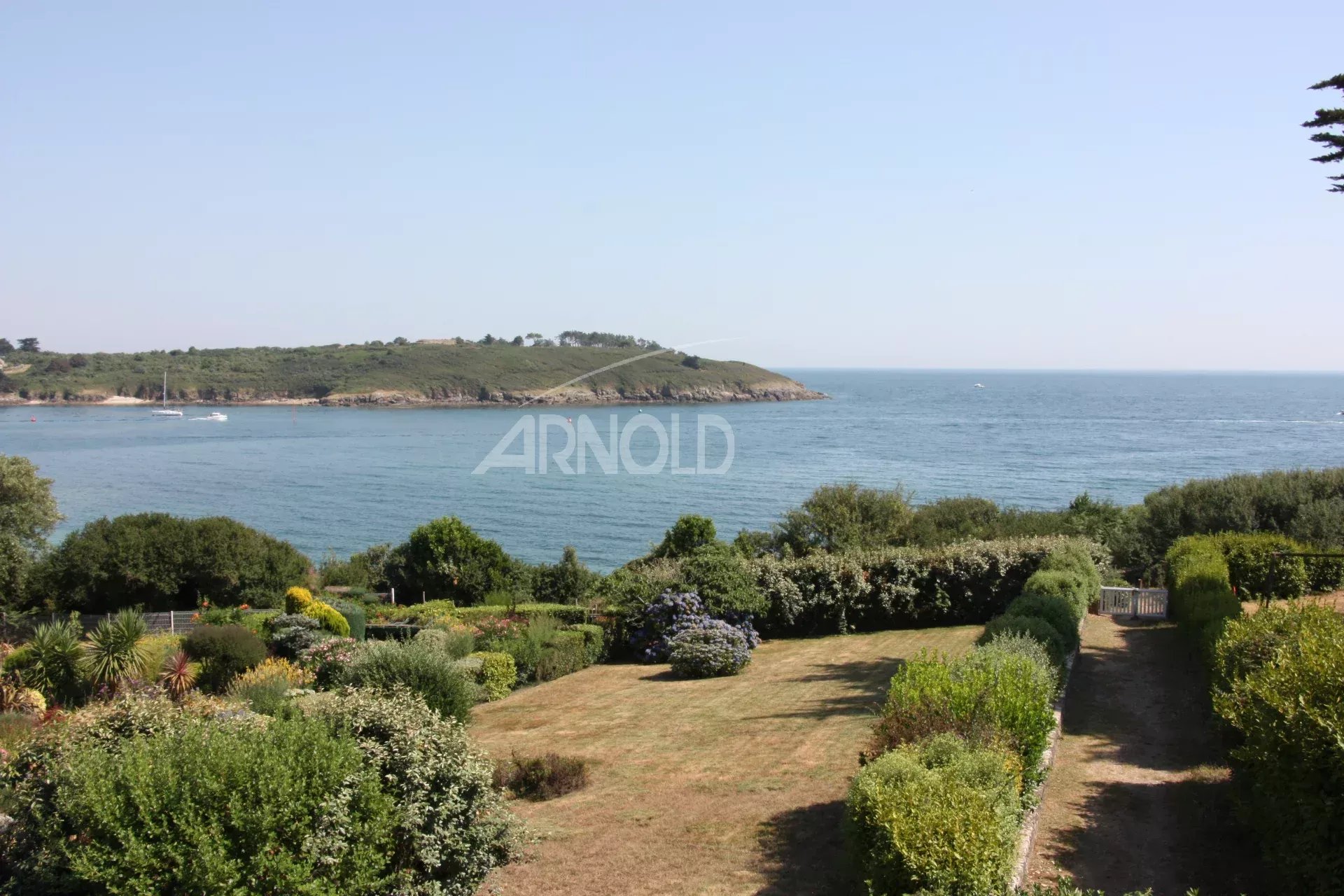 Vue sur l’océan à Arzon Vue panoramique sur l'océan et la plage depuis un terrain paysagé à Arzon.