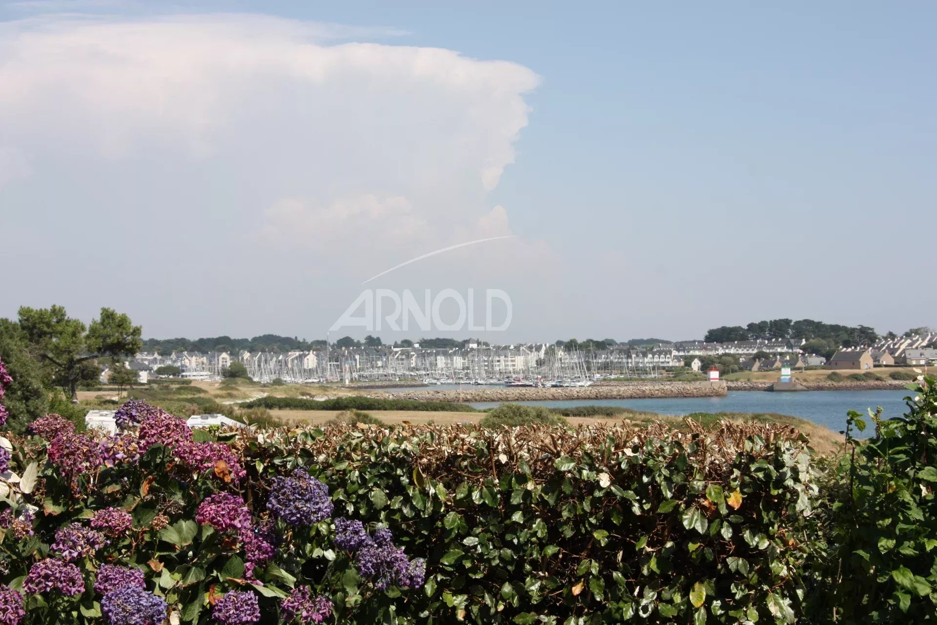 Vue sur l’océan à Arzon Vue panoramique sur l'océan et la plage depuis un terrain paysagé à Arzon.