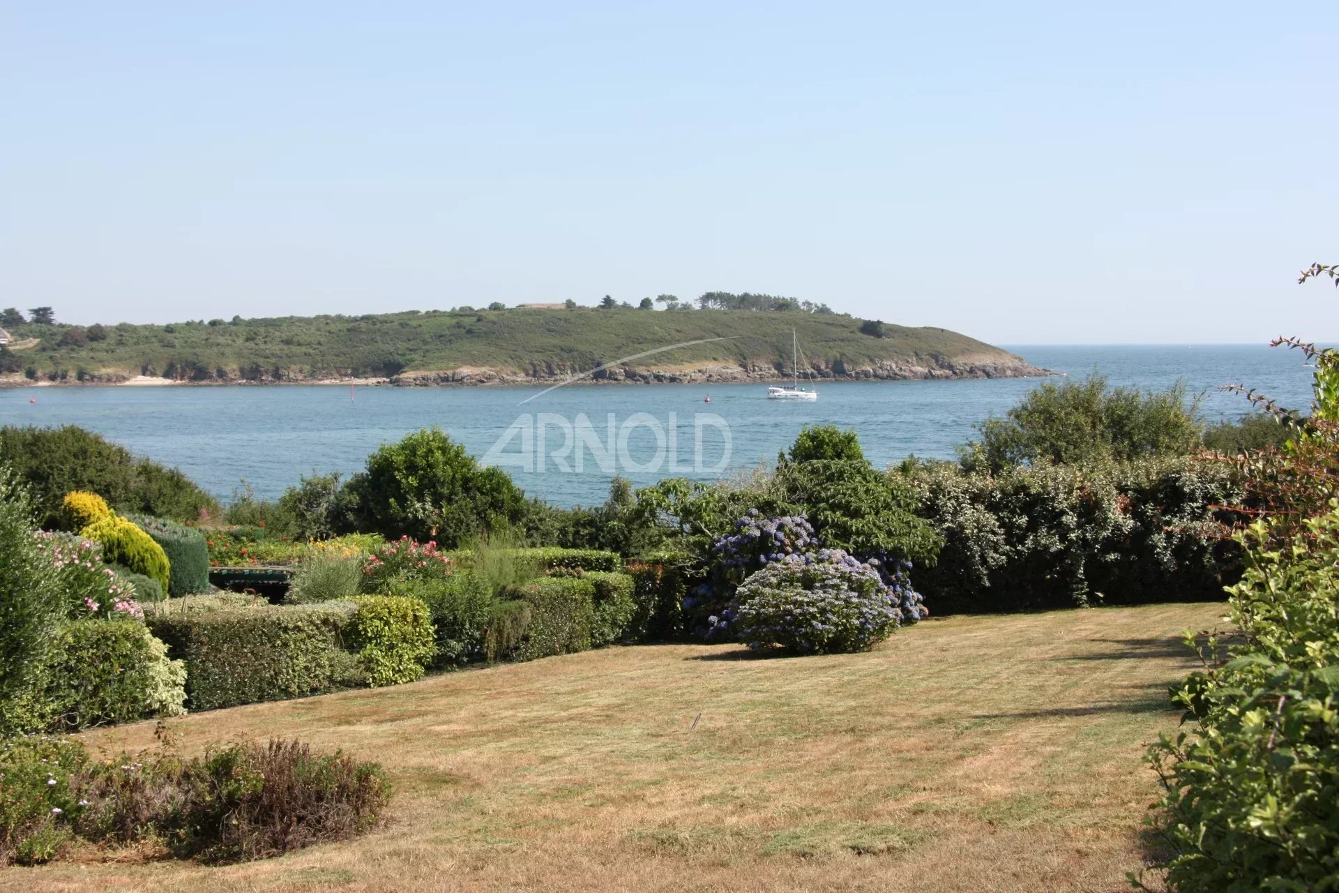 Vue sur l’océan à Arzon Vue panoramique sur l'océan et la végétation depuis un jardin à Arzon, près de Port Navalo.