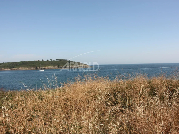 Vue panoramique sur l'océan et la plage depuis un terrain paysagé à Arzon.