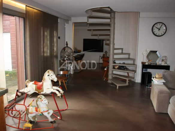 Intérieur d'une maison familiale à Vannes avec un escalier moderne et des objets décoratifs.