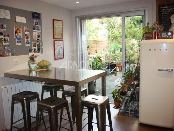 Intérieur d'une maison familiale à Vannes avec cuisine ouverte et accès à un jardin.
