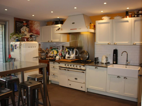 Cuisine moderne avec îlot central et équipements complets dans une maison familiale.