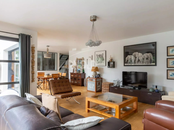Intérieur d'une maison contemporaine avec salon, salle à manger et télévision.