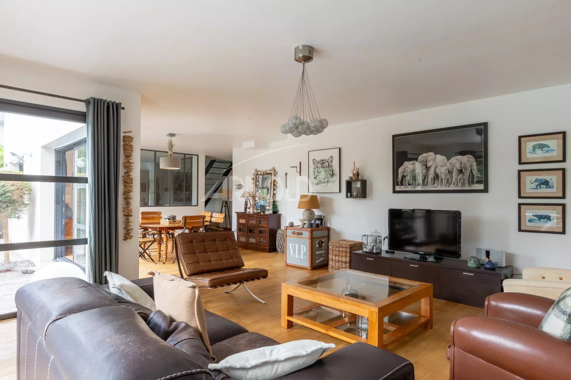 Intérieur d'une maison contemporaine avec salon, salle à manger et télévision.