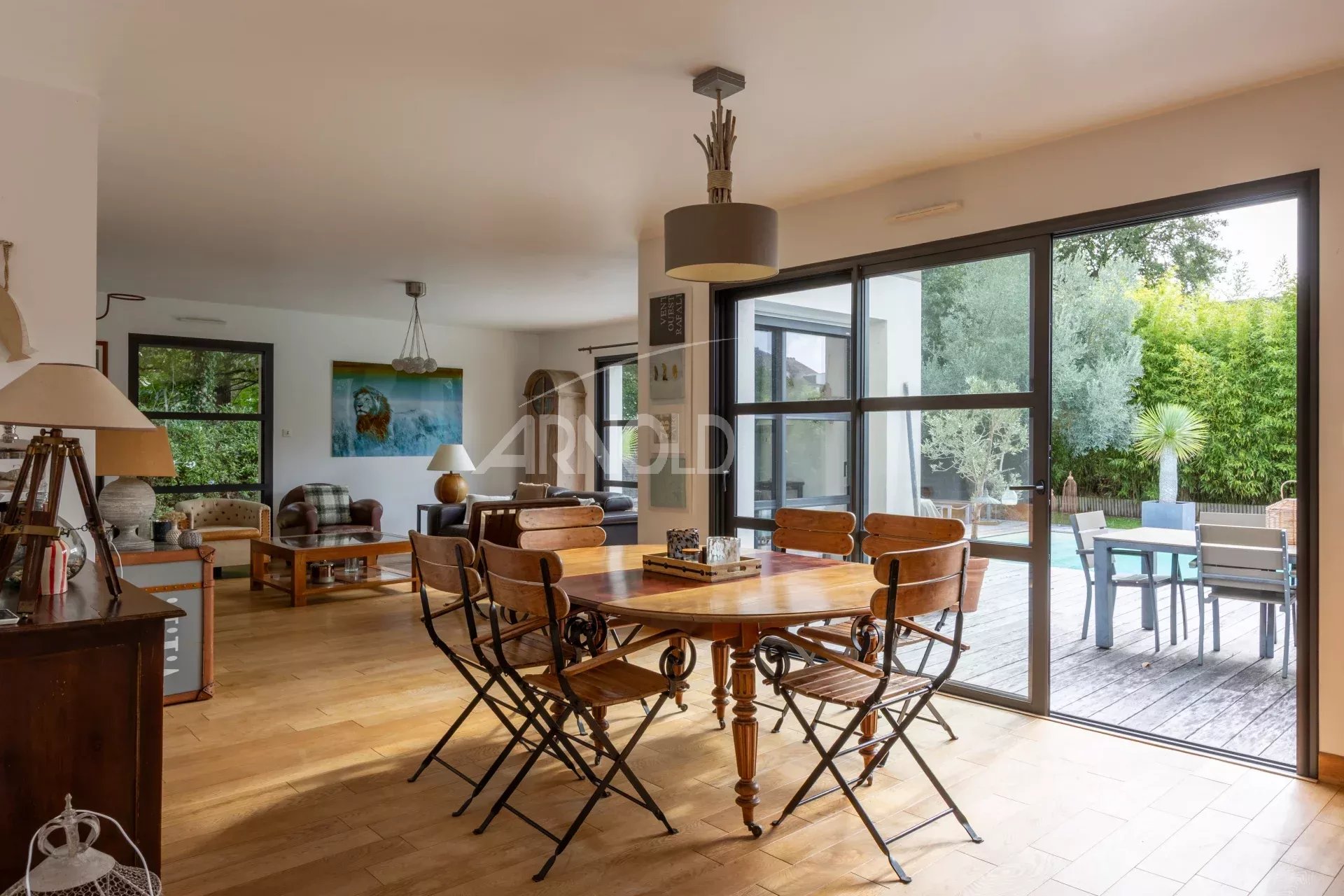 Intérieur d'une maison contemporaine avec salle à manger et accès à la piscine.