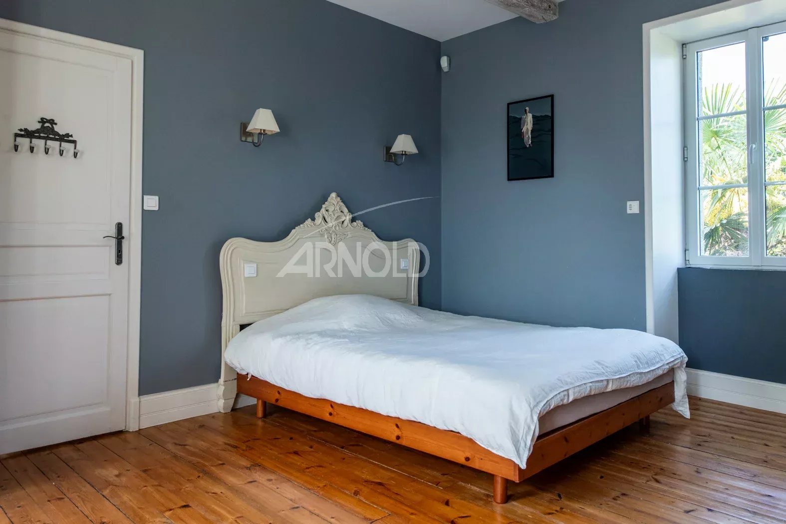 Chambre élégante à Saint-Avé Chambre d'une propriété rénovée avec un lit en bois et des murs gris à Saint-Avé près de Vannes.