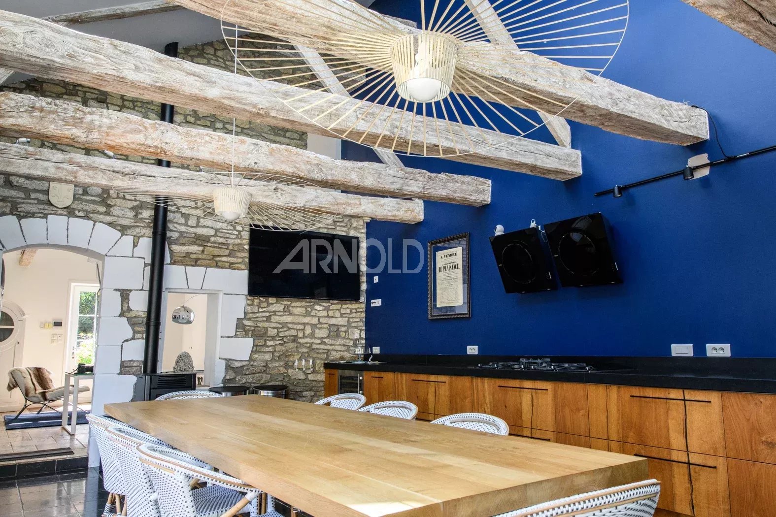 Cuisine moderne dans une propriété de charme Intérieur d'une propriété rénovée avec poutres apparentes et table en bois dans une cuisine moderne.