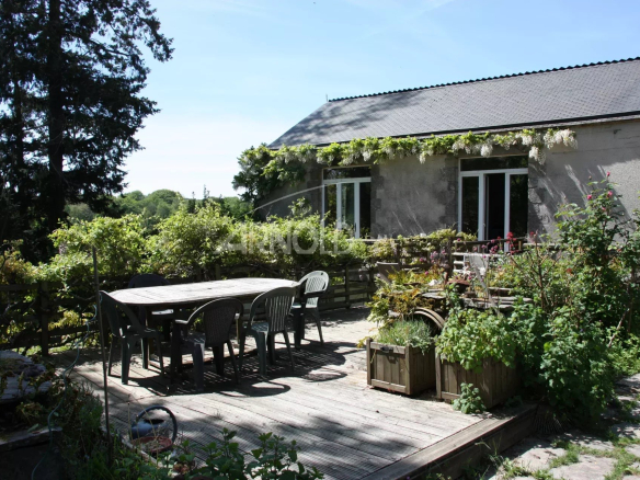 Demeure en pierre avec terrasse et jardin dans un village français.