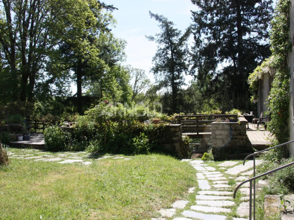 Jardin avec chemin en pierre et étang dans une demeure à Rochefort-en-Terre.