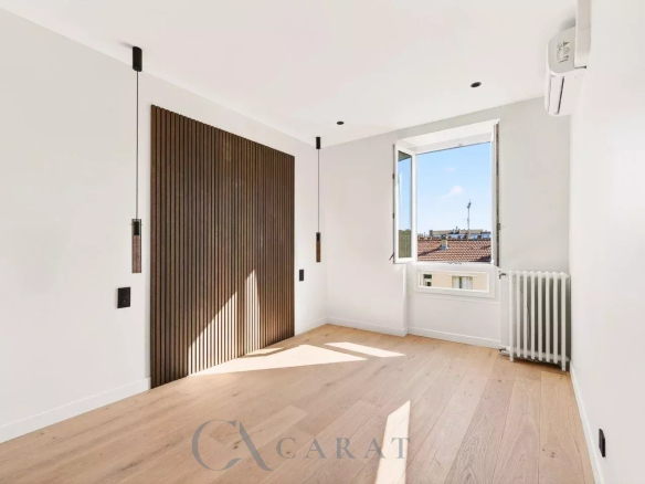 Bright, modern empty room with a dark wooden slat wall, two pendant lights, and a large open window letting in sunlight.