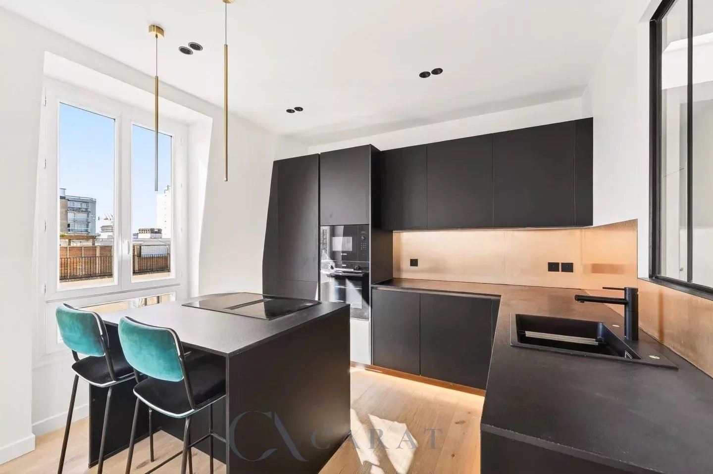f6c5a13a68c8217360850e0cf74a207a_5e67ff280b_1440-original Modern black kitchen with copper backsplash, island cooktop, and teal-bar stools by a large window overlooking the city.