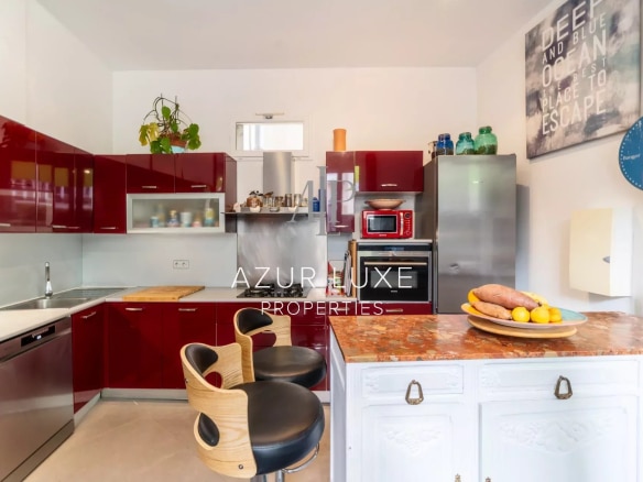 Modern kitchen with red furniture and marble countertop in a house in Nice.