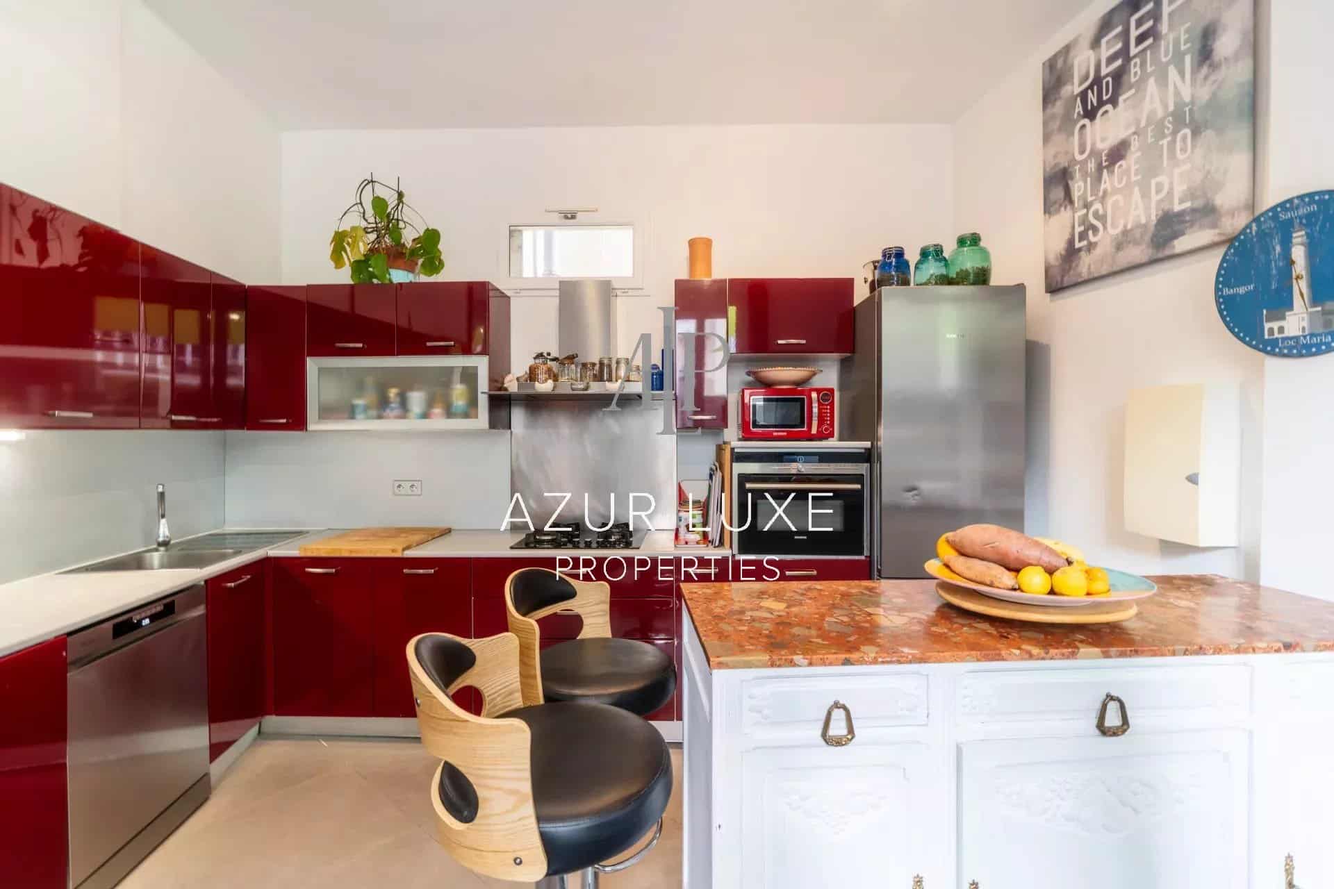 Kitchen of Villa Mireille in Nice Modern kitchen with red furniture and marble countertop in a house in Nice.
