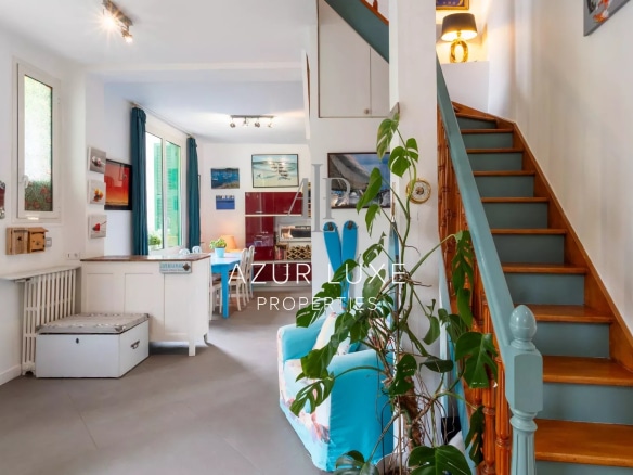 Interior of a townhouse in Nice, with a wooden staircase and a bright living space.