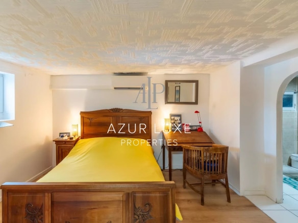 Room with wooden bed and desk in a house in Nice.