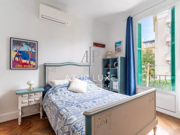 Bright room with a bed, wooden furniture and a window overlooking the outside.