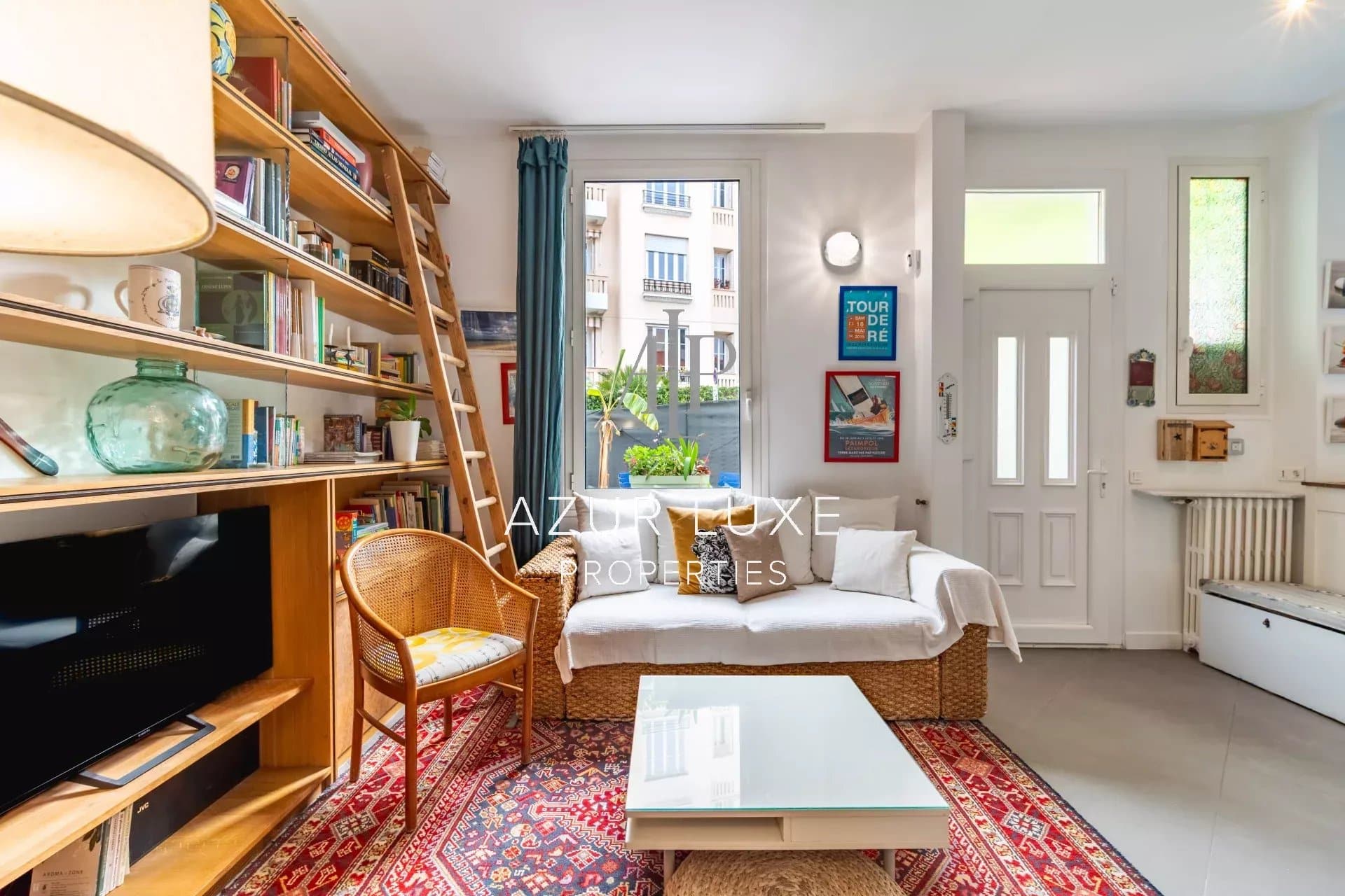 Bright living room of Villa Mireille in Nice Interior of a townhouse in Nice, with a bright living room, shelves and access to the outside.