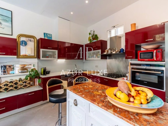 Modern kitchen with red furniture and a marble worktop, bright and spacious.