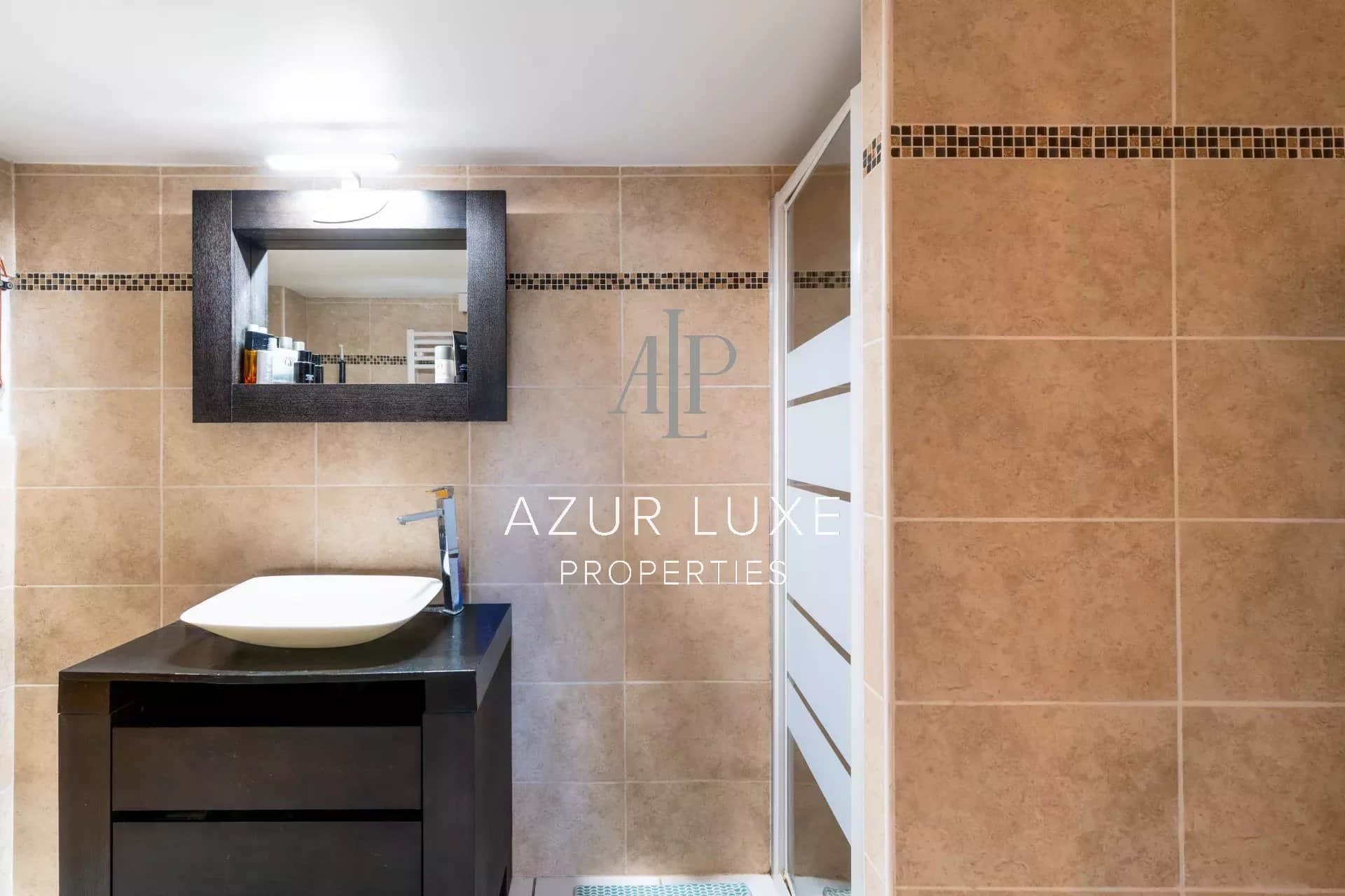 Bathroom of Villa Mireille in Nice Modern bathroom with sink and mirror, beige tiles