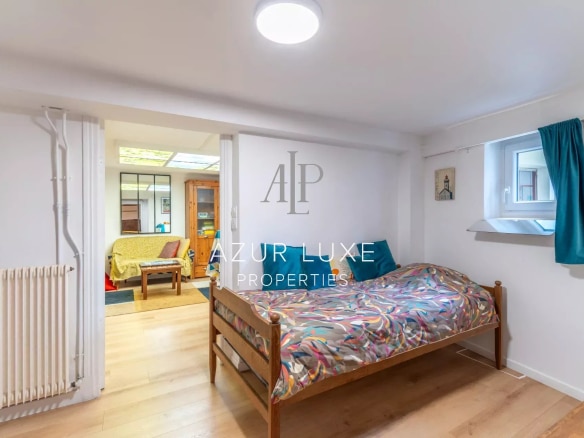 Ground floor bedroom in a townhouse in Nice, decorated with a bed and storage units.