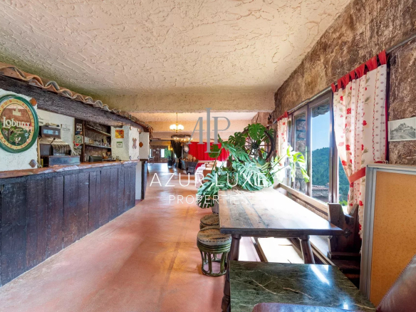 Intérieur d'un ancien hôtel-restaurant avec bar et tables en bois, décor vintage.