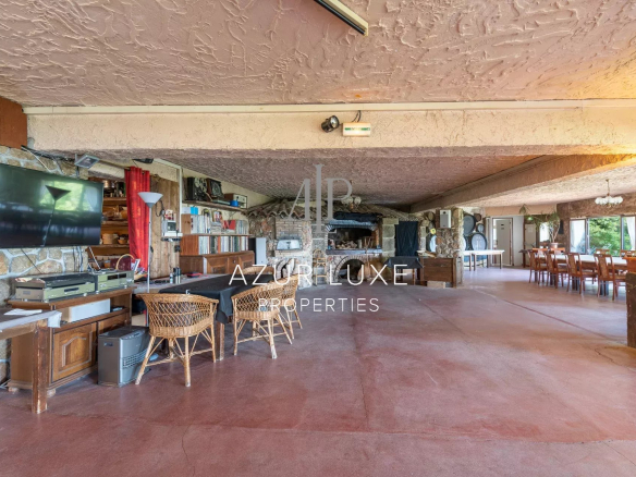 Intérieur d'un ancien hôtel-restaurant avec cheminée et espace repas, à Castillon.
