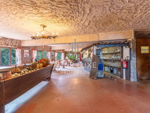 Intérieur d'un ancien hôtel-restaurant avec tables et décoration rustique à Castillon.