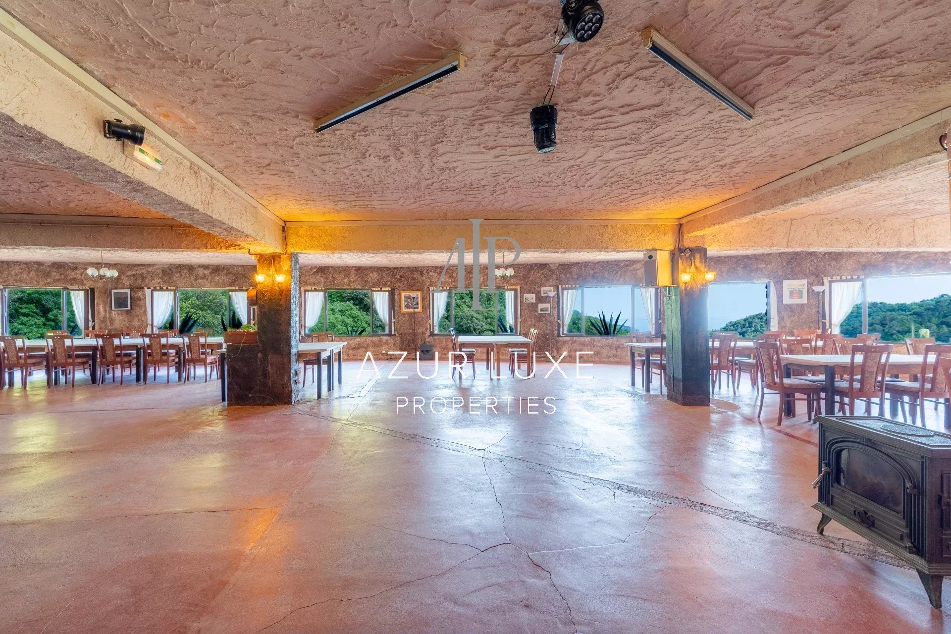 Interior of a former hotel-restaurant in Castillon Interior of a former hotel-restaurant with tables and chairs, view of nature outside.