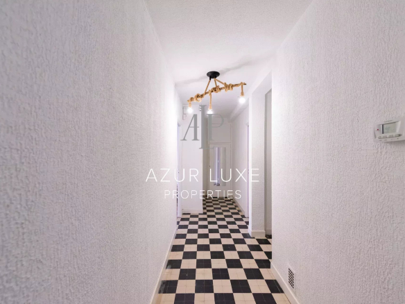 Entrance hall of an apartment to be renovated with black and white tiles.