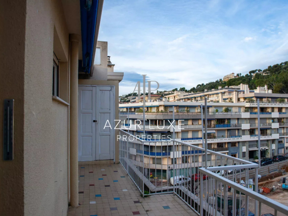 Balcony of an apartment in Beaulieu-sur-Mer with views of buildings and hills.