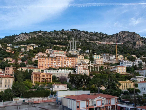 Panoramic view of Beaulieu-sur-Mer with colorful buildings and hills in the background.