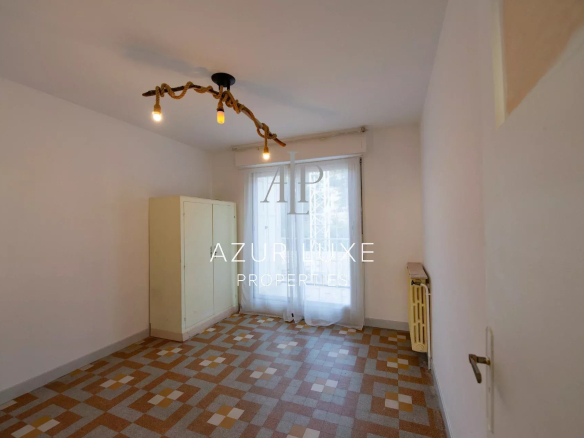 Interior of an apartment to be renovated with a tiled floor and a window overlooking the outside.