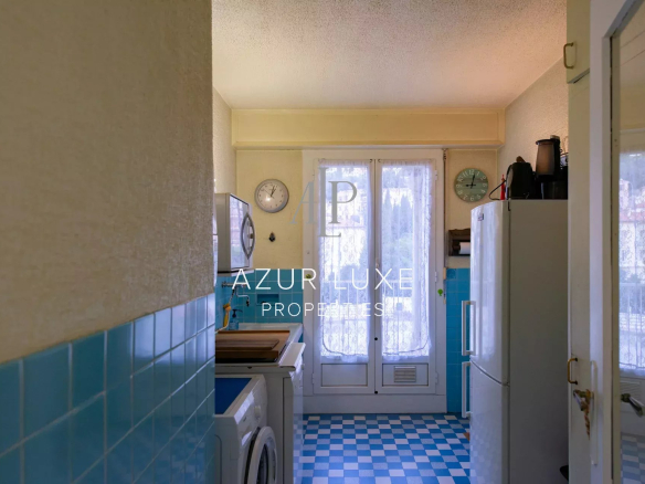 Kitchen of an apartment to be renovated with blue tiles, windows and appliances visible.