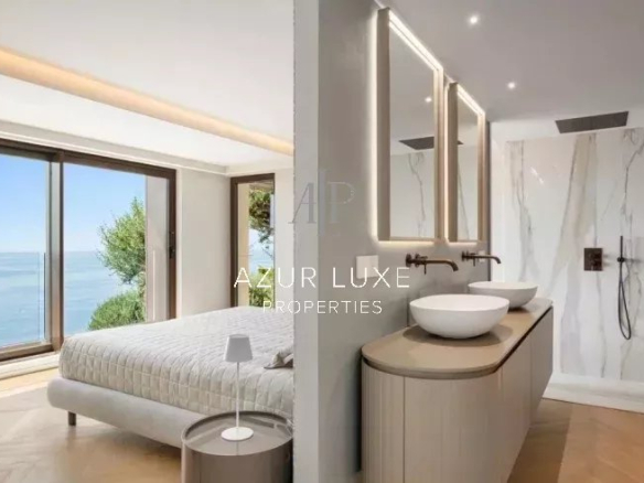 Chambre moderne avec vue sur la mer, salle de bain élégante et grandes fenêtres à Roquebrune-Cap-Martin.
