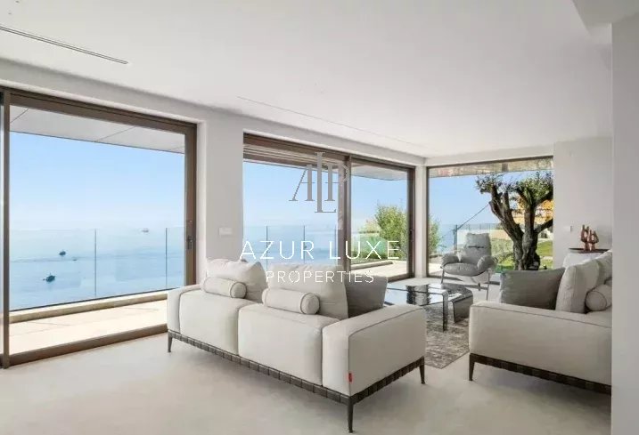 Villa moderne avec vue panoramique Intérieur d'une villa moderne avec vue mer, salon lumineux et mobilier contemporain.