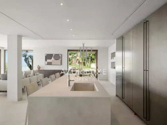 Intérieur d'une villa moderne avec cuisine ouverte et vue sur la mer à Roquebrune-Cap-Martin.