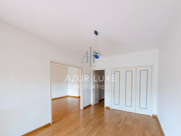 Interior of an apartment to be renovated with light walls and parquet flooring, white windows and doors.