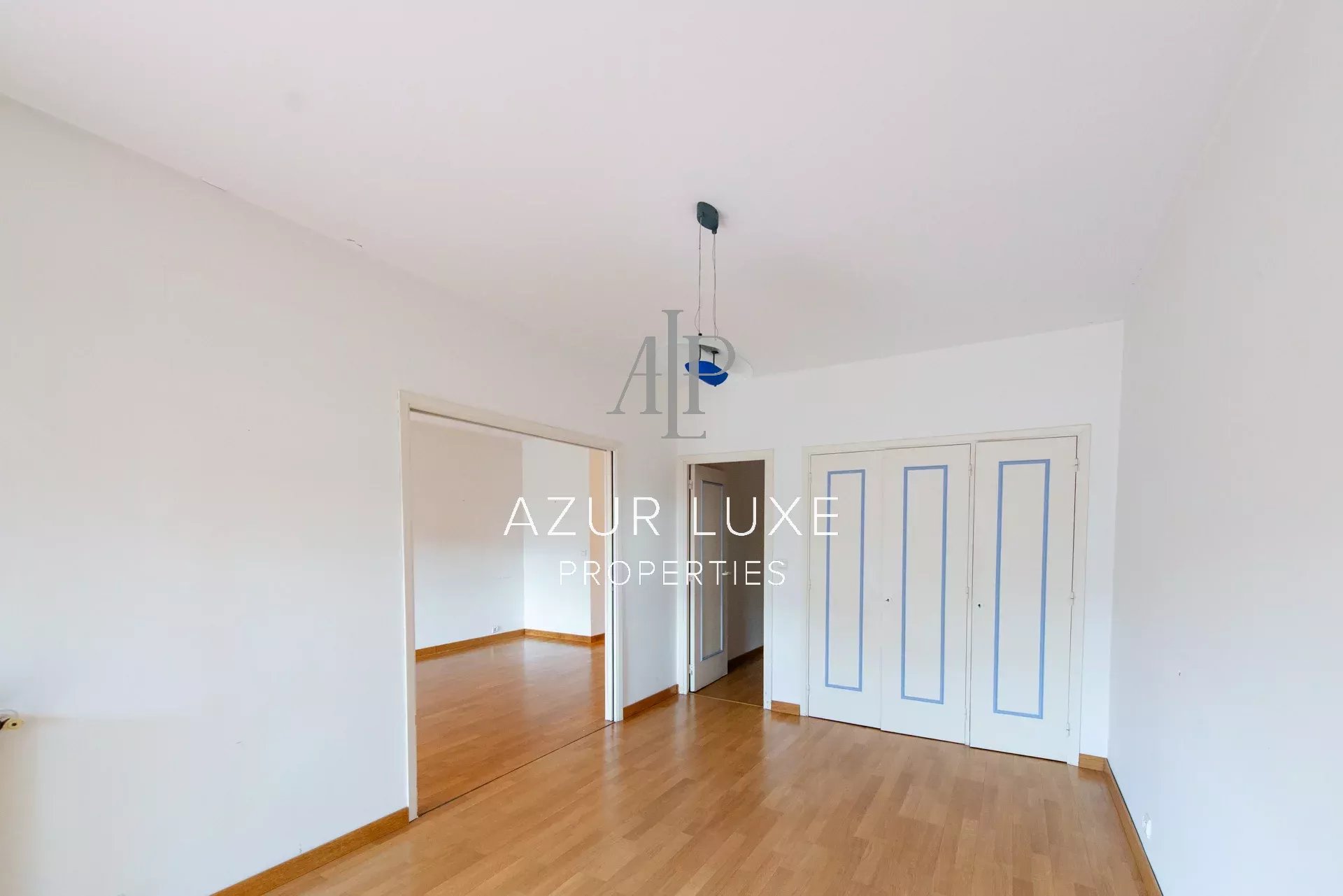 Apartment to renovate in Beaulieu-sur-Mer Interior of an apartment to be renovated with light walls and parquet flooring, white windows and doors.