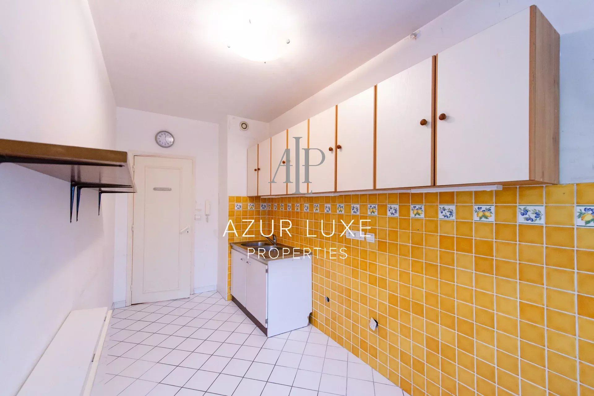 Kitchen to renovate in an apartment Kitchen of an apartment to be renovated with yellow tiles and white furniture, Beaulieu-sur-Mer.