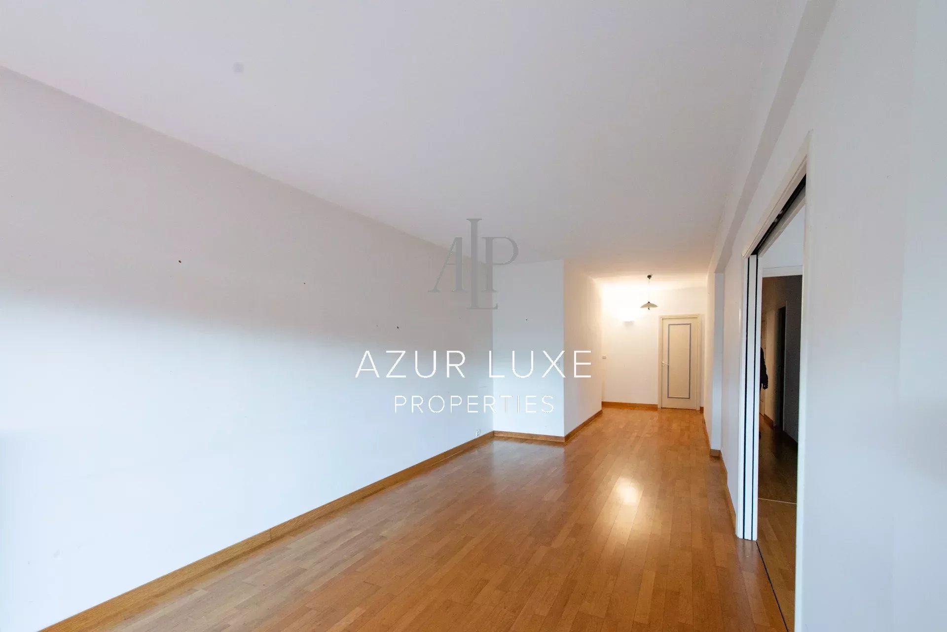 Apartment to renovate in Beaulieu-sur-Mer Interior of an empty apartment with a wooden floor, white walls and natural light.