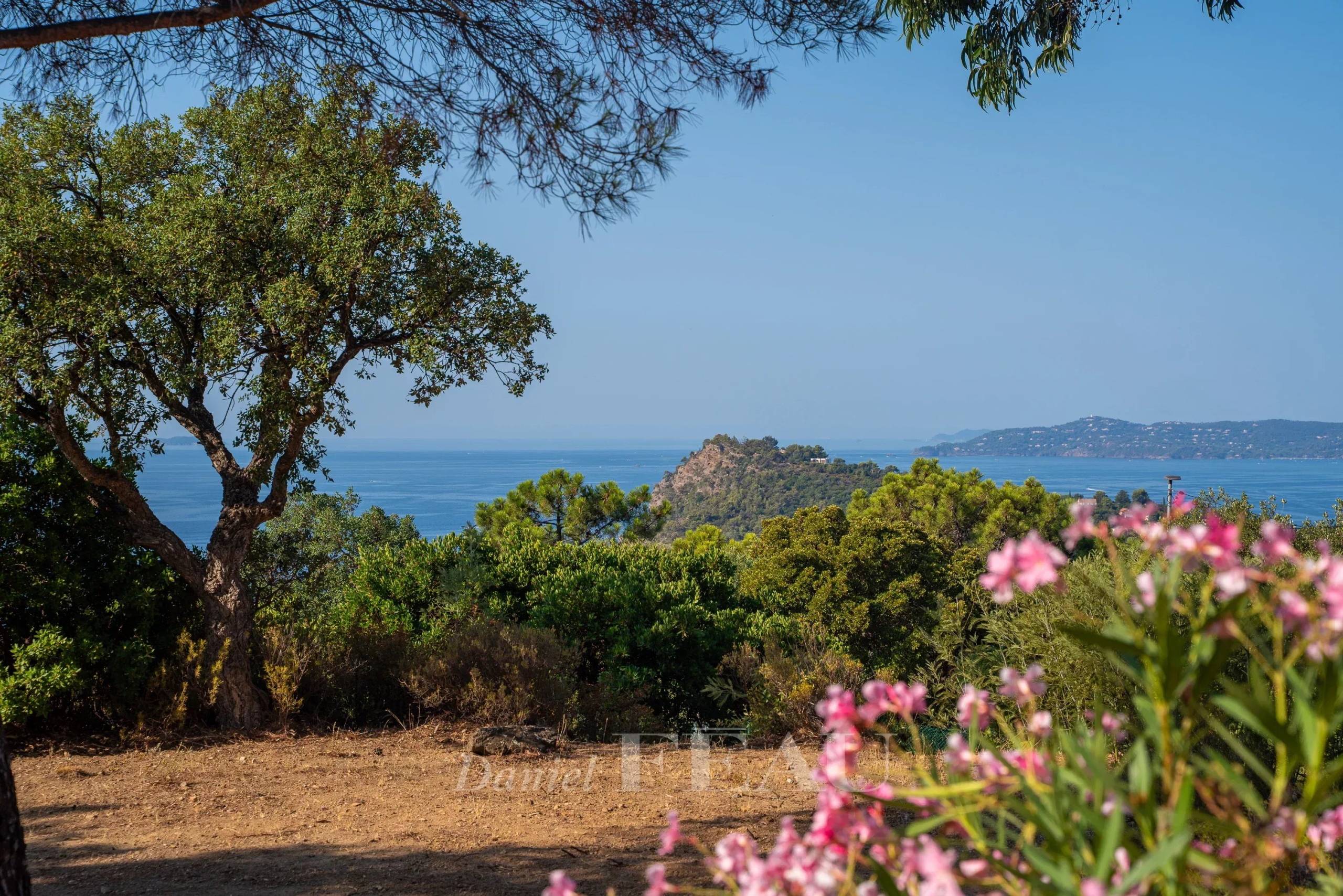 Villa with sea view in Rayol-Canadel-sur-Mer Panoramic sea view from a villa in Rayol-Canadel-sur-Mer, with flowers in the foreground.