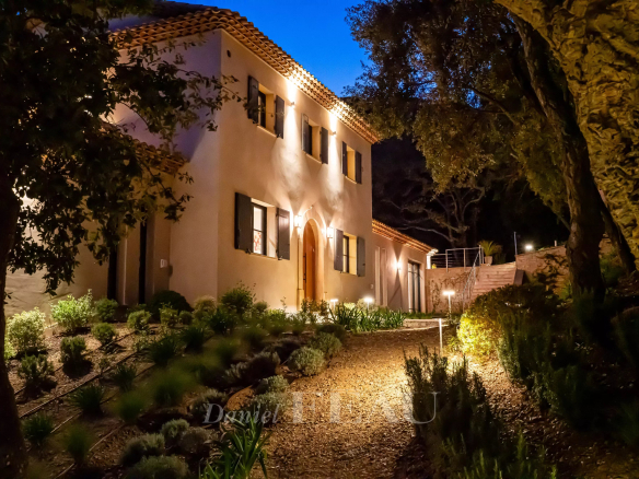 Maison moderne illuminée dans un cadre naturel à La Croix-Valmer, entourée de végétation.