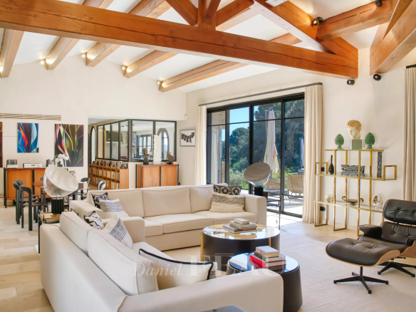 Intérieur d'une propriété moderne à La Croix-Valmer avec un salon lumineux et des poutres en bois.