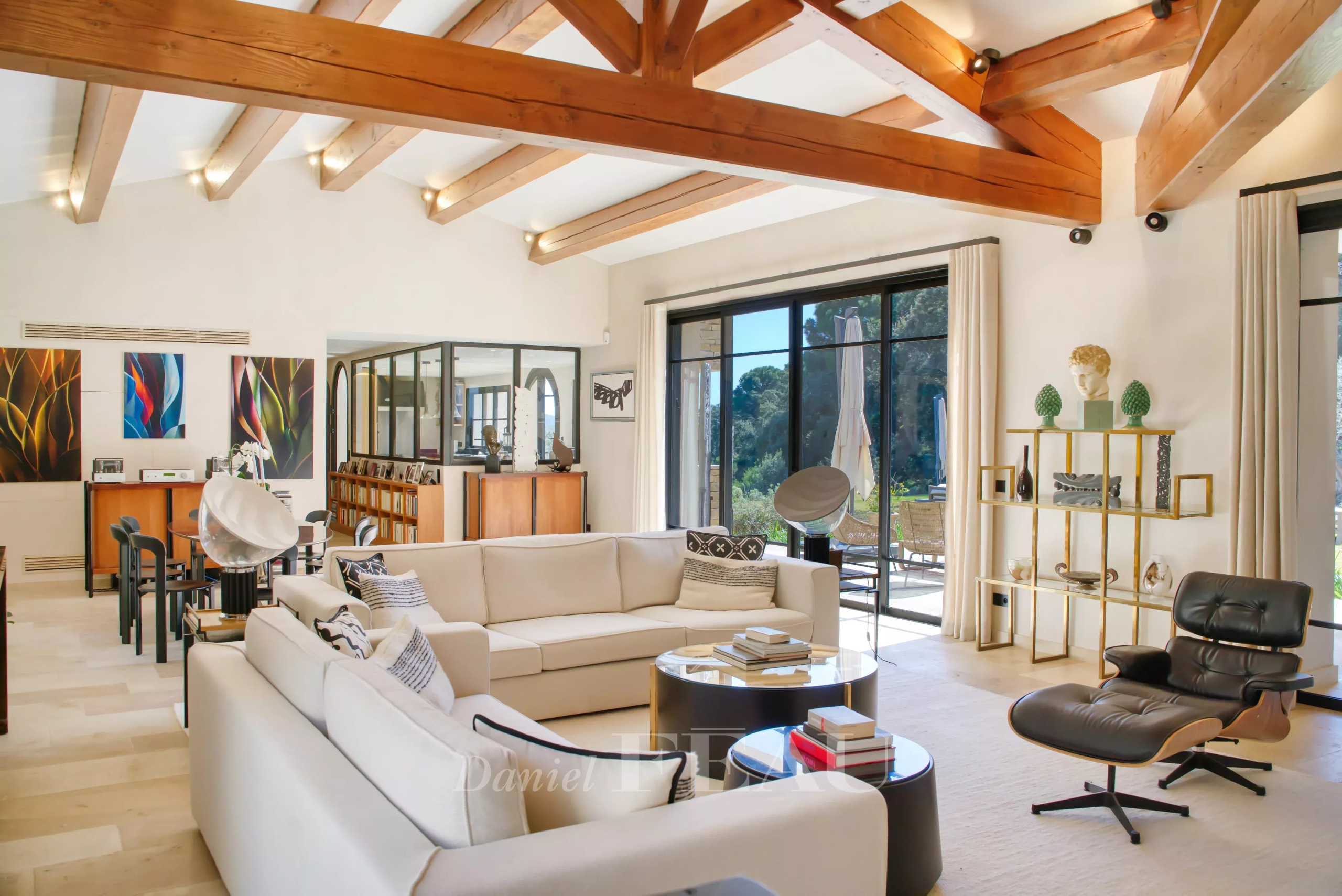 Salon d’une propriété d’exception à La Croix-Valmer Intérieur d'une propriété moderne à La Croix-Valmer avec un salon lumineux et des poutres en bois.