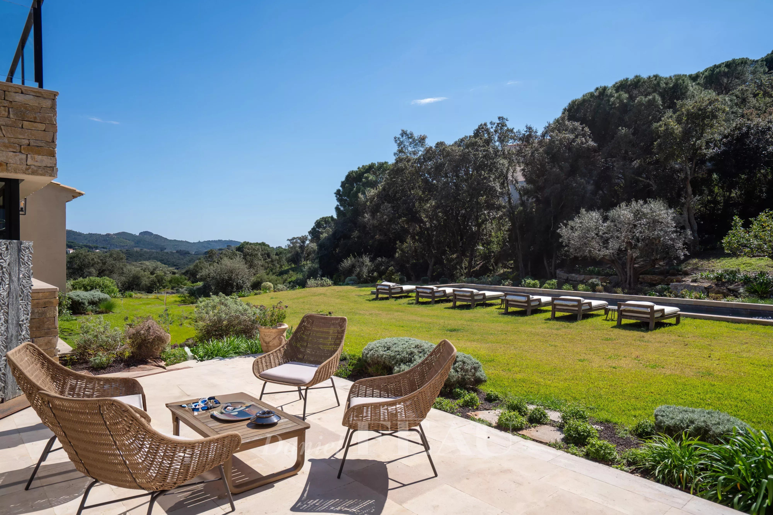 Propriété d’exception à La Croix-Valmer Terrasse d'une propriété moderne avec des fauteuils en osier et un jardin verdoyant à La Croix-Valmer.