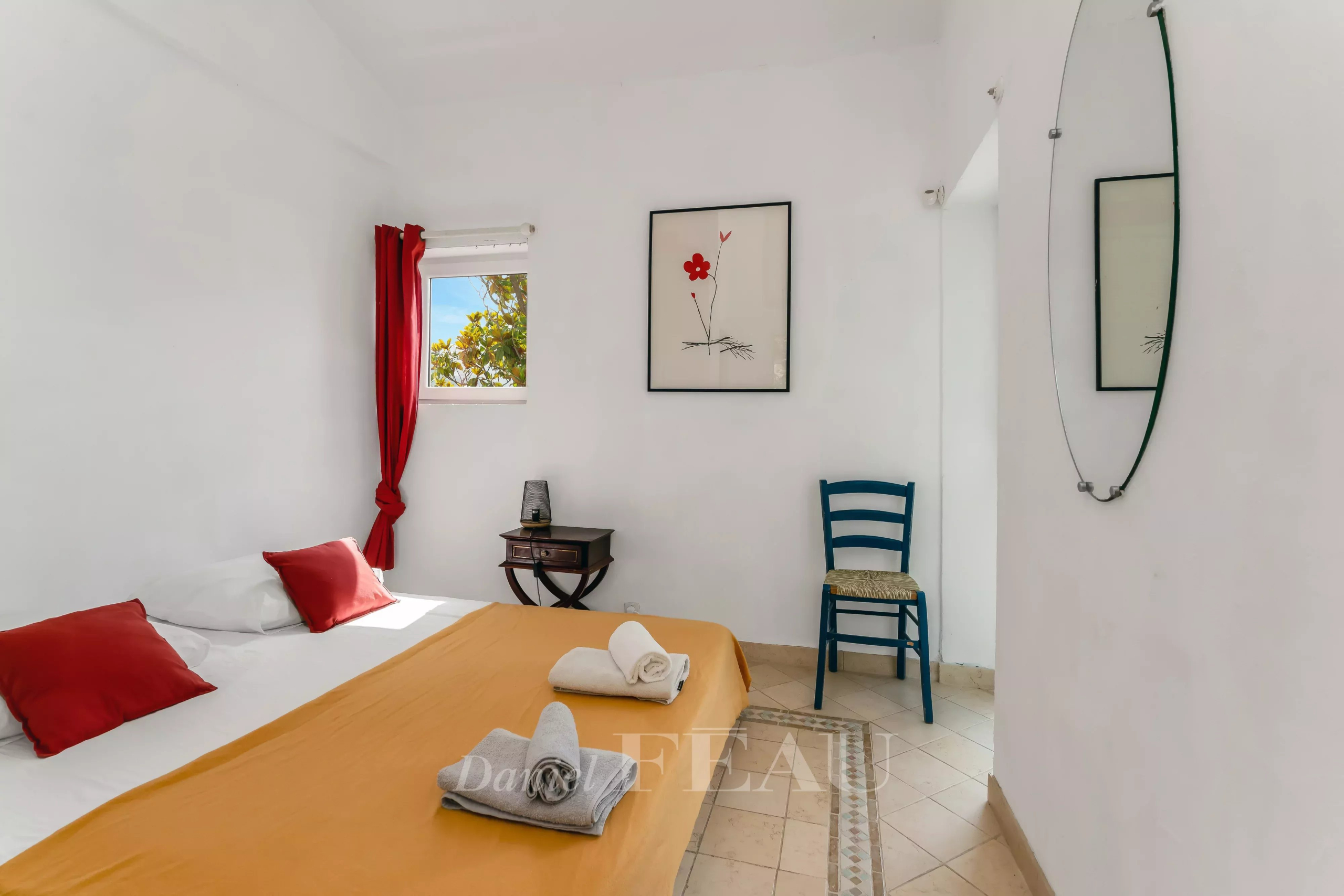 Chambre d'une villa à Rayol-Canadel avec lit, décoration simple et vue sur l'extérieur.