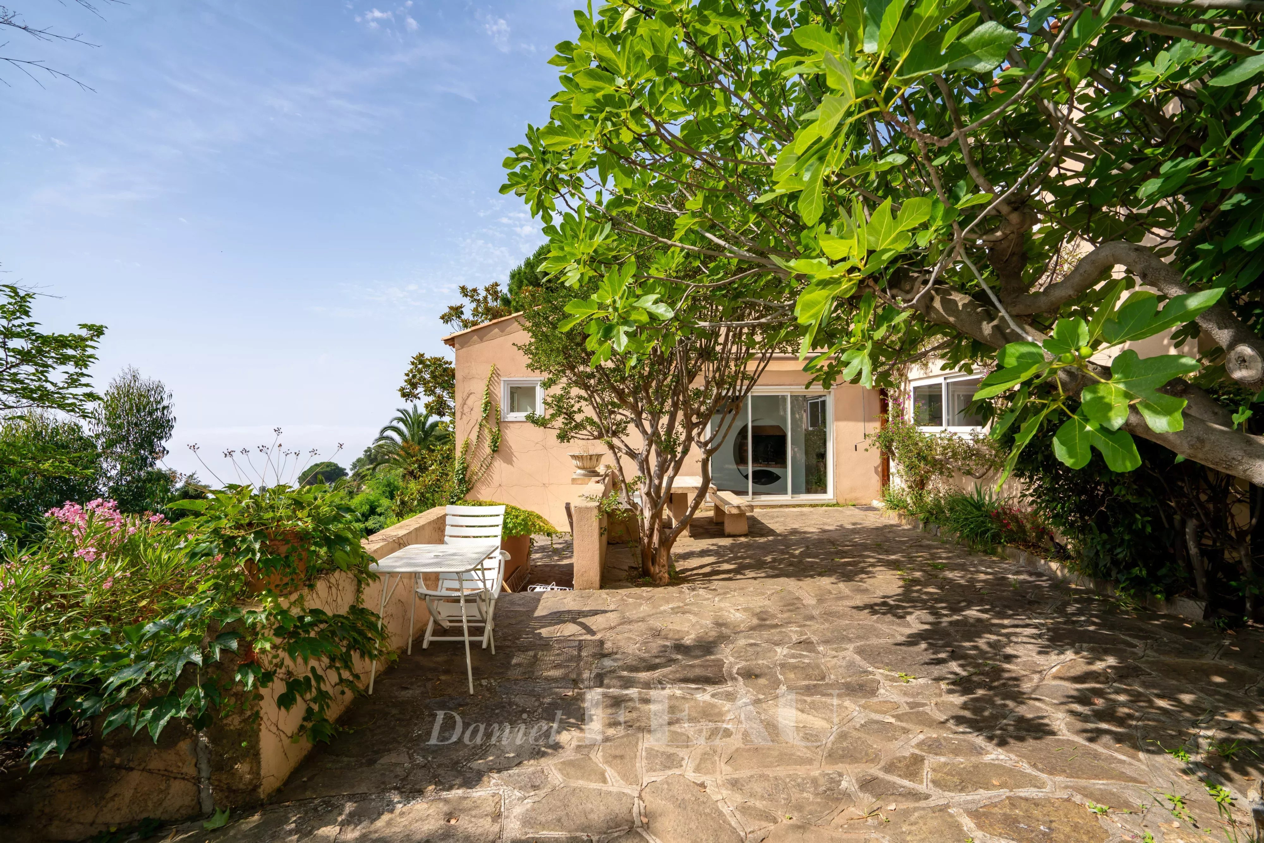 Villa avec vue mer à Rayol-Canadel, terrasse en pierre et végétation environnante.